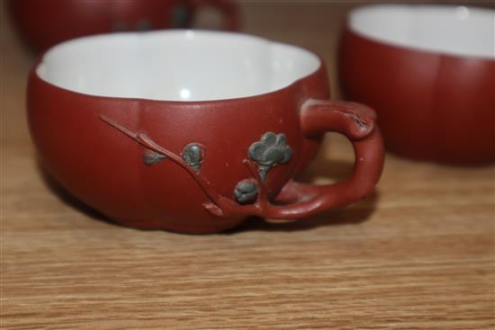 A Yixing pottery teapot and three cups